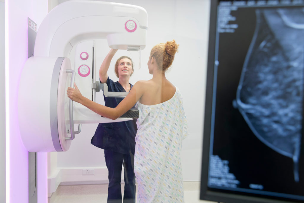 Mulher realizando mamografia para avaliação da densidade mamária
